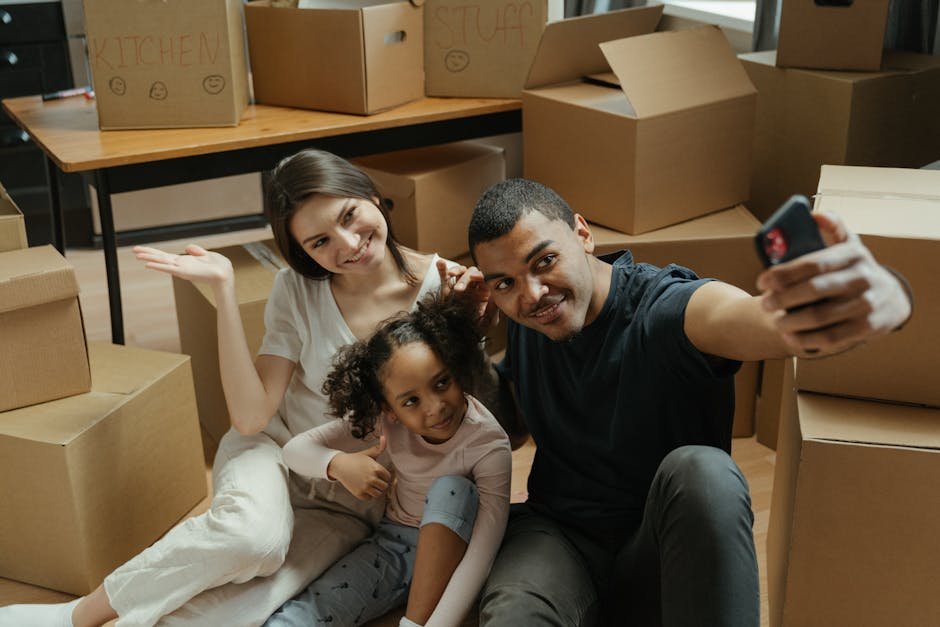 A joyful family taking a selfie amidst moving boxes in their new apartment.