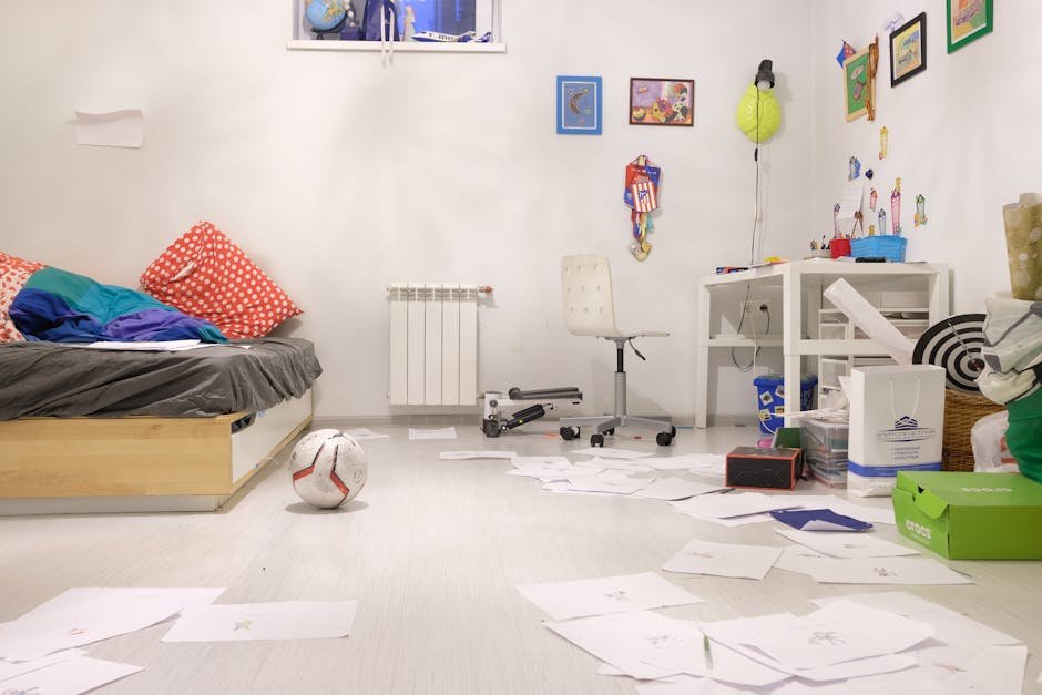 Messy kids' room with scattered papers and toys, showing lively disorder.